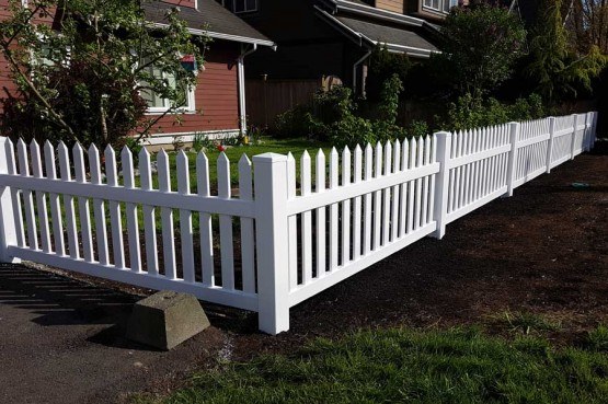vinyl picket fence surrounding residential home backyard