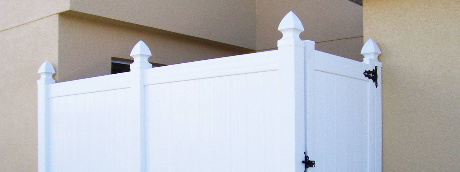 white vinyl fencing with decorative top pieces on each pillar