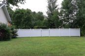 pvc vinyl privacy fence in residential backyard surrounded by trees
