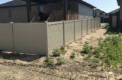 under construction area with home surrounded by pvc privacy final fence