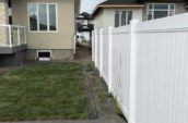 pvc vinyl privacy fence lining side of home backyard