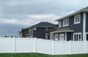 pvc vinyl privacy fence lining side of home backyard