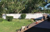 home backyard with large deck surrounded by pvc vinyl privacy fence