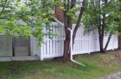 huron semi-privacy vinyl fence gate on the side of home beneath trees