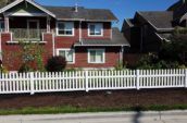 short vinyl picket fence surrounding backyard of home